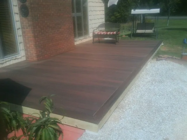 Freshly stained wood deck built against a brick home in West Lebanon
