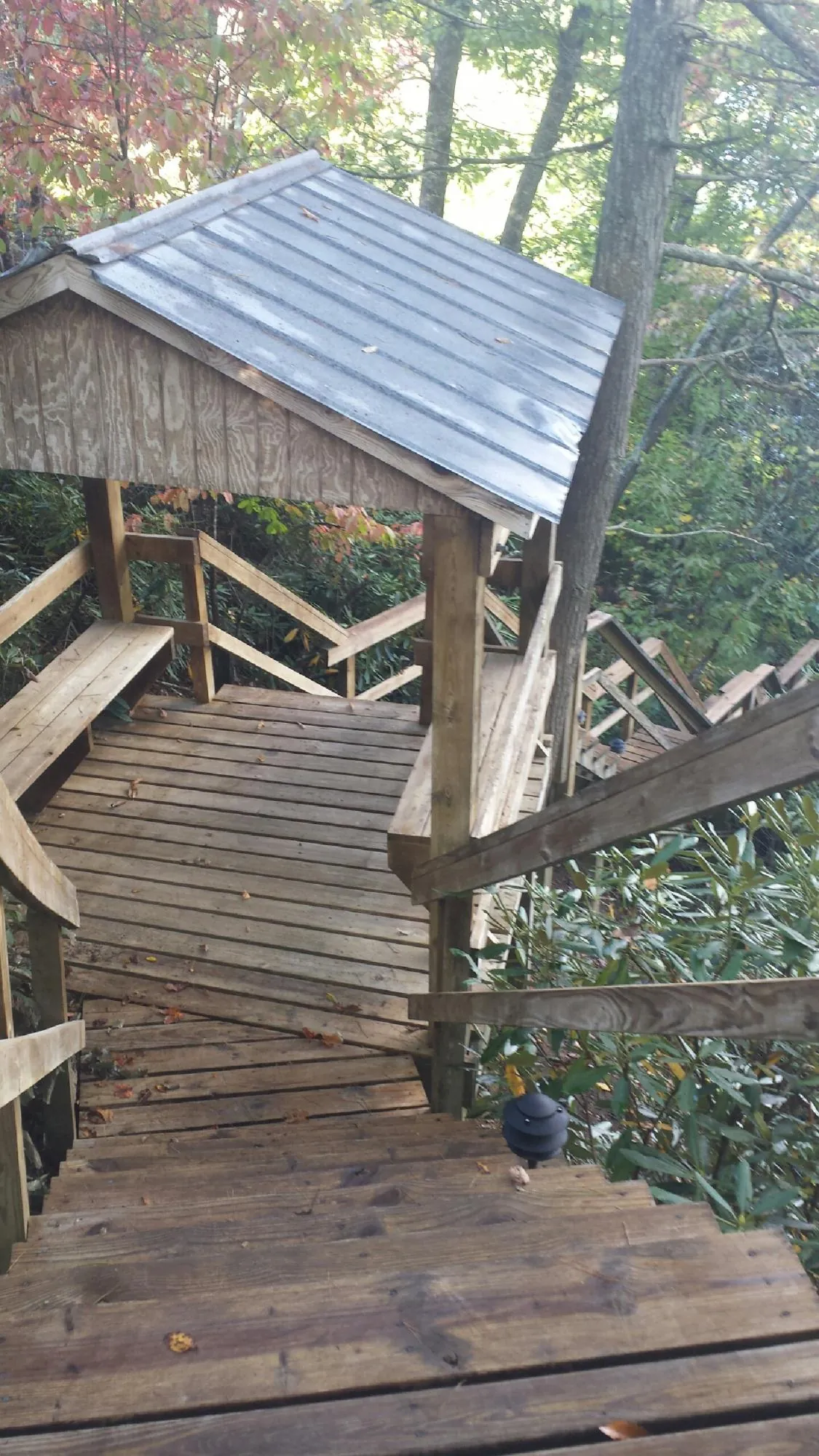 Metal roofed shelter over wooden steps on a wooded walkway — Skylight Repair & Installation work by our crew in West Lebanon